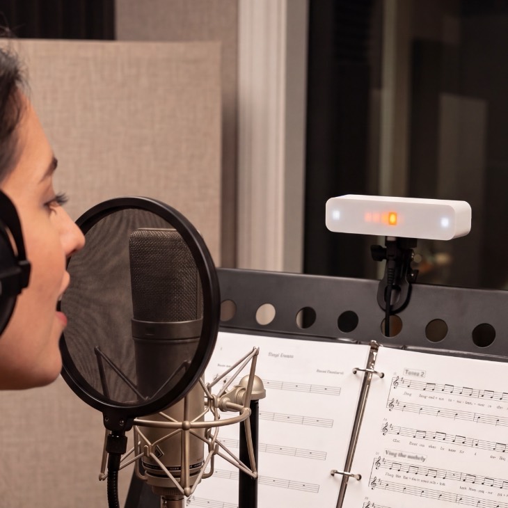 Vistanome in a recording booth with orange beat color, clipped to a music stand.
